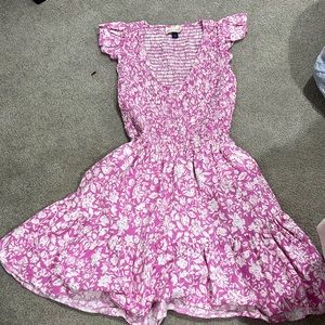 A pink dress with white flowers and kinda low cut